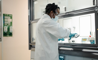 Homme dans un laboratoire en blouse avec un masque et des gants